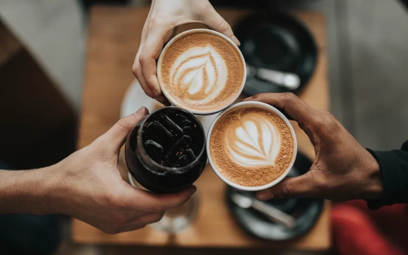 Three people cheering iced coffee